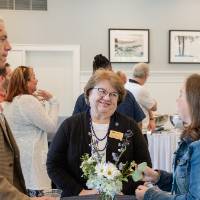 Dean Linda Lewandowski chatting with two other event attendees around table